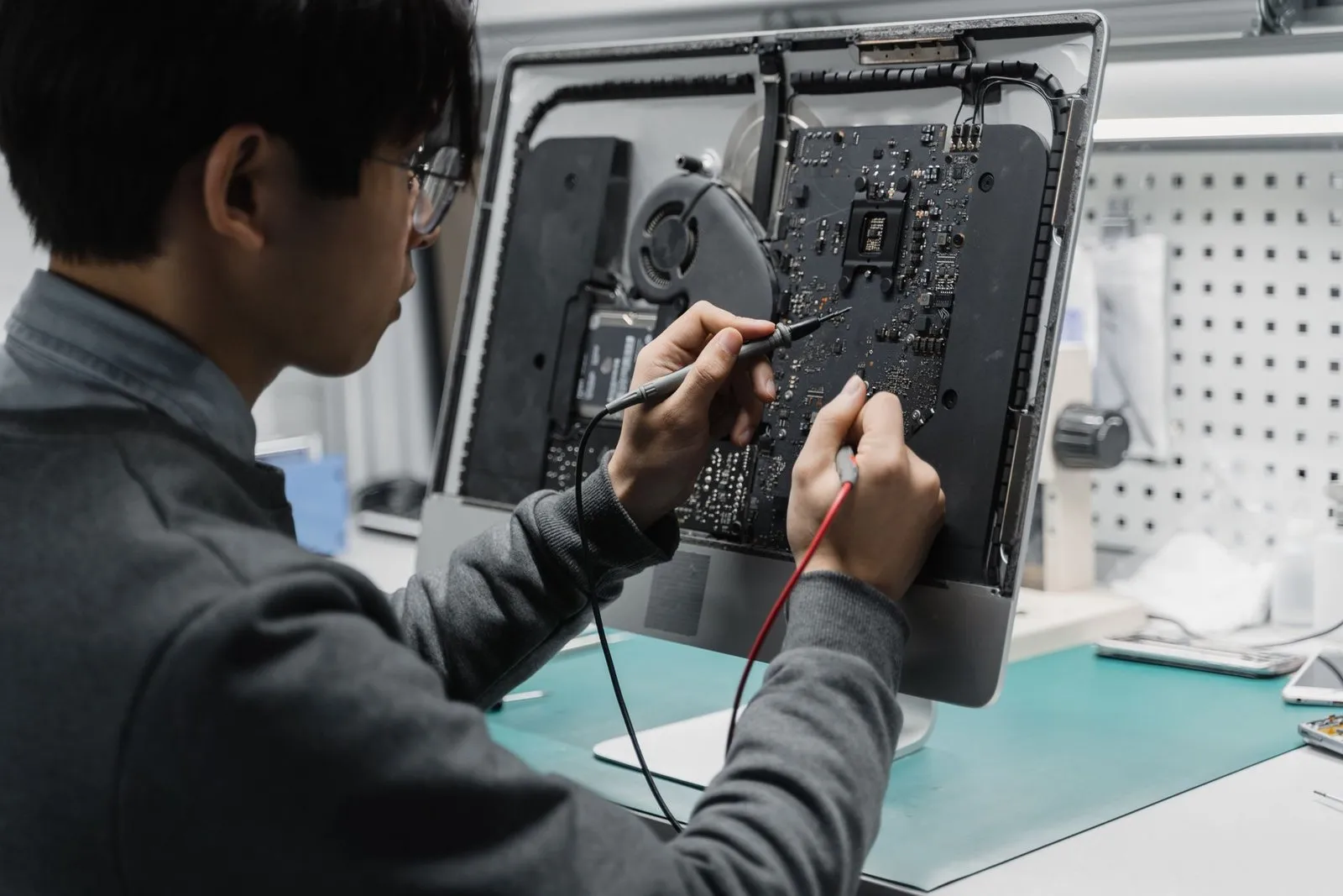 Technician repairing computer hardware at a workbench